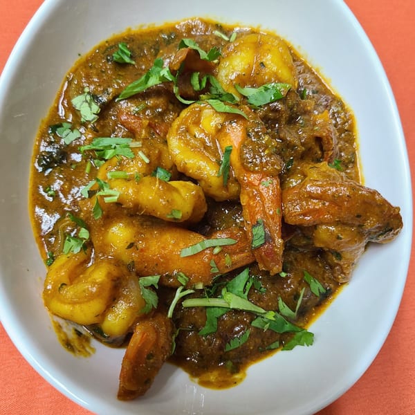 New Little India's shrimp curry, a rich brown dish with plump shrimp and fresh cilantro in a white bowl.